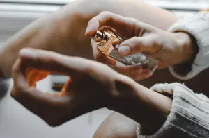 Pastelowa wiosenna stylizacja: kwiecista sukienka, lekki trencz, słomkowy kapelusz, torebka i sneakersy w estetyce Pinterest.
